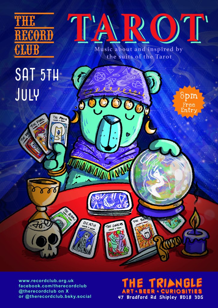 The Record Club bear dressed as a fortune teller in a tent, with a crystal ball, a pile of tarot cards and assorted fortune teller paraphernalia. 